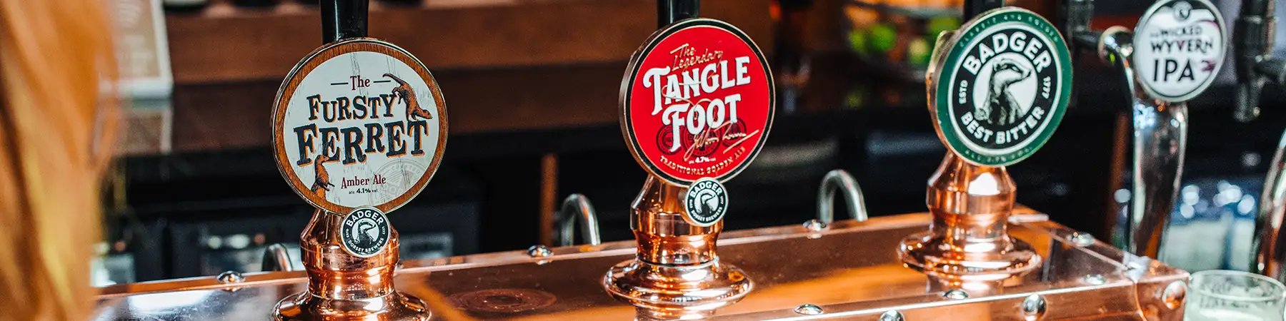 mixed logos of badgers brewery logos on taps