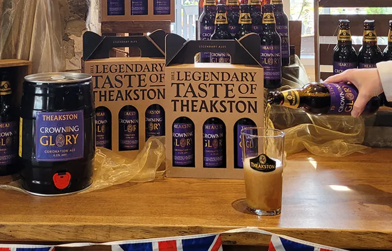 display of Theakston growing glory with pint being poured from a bottle on a table