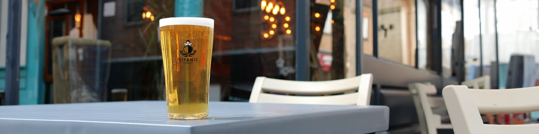 pint of titanic beer on table outside a bar