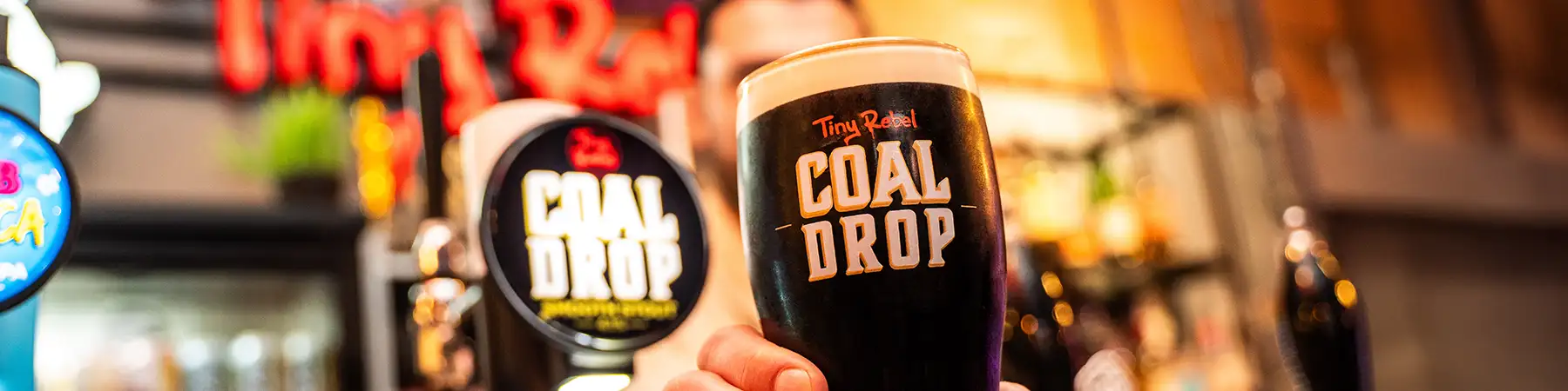 Closeup shot of Tiny Rebel Coal Drop pint in a bar setting